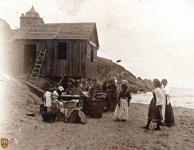 Grupo de mujeres y niños en una caseta de madera de la playa (1896) Ennegrecimiento directo 